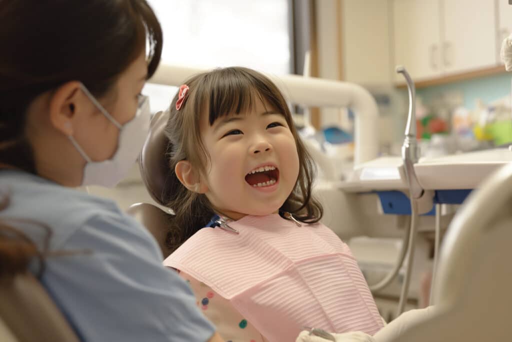 日本の小さな女の子が歯科医院で笑顔を見せる